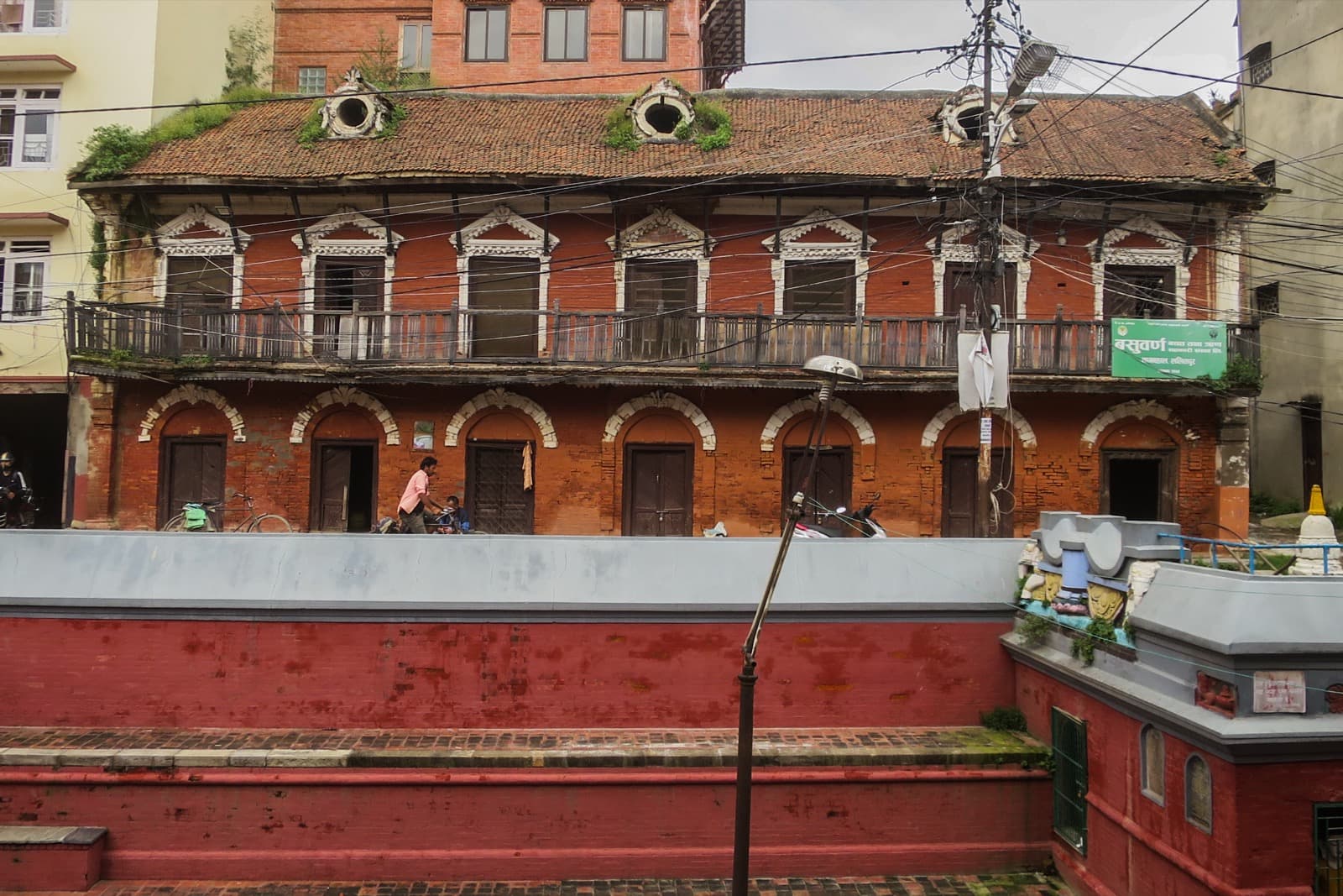 Nag Bahal courtyard with stone water spout (hiti) and Rana-era building