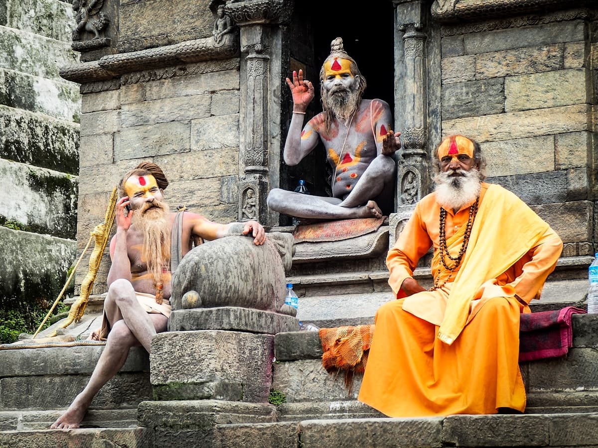 Three monks sitting on the temple steps at Pashupatinath