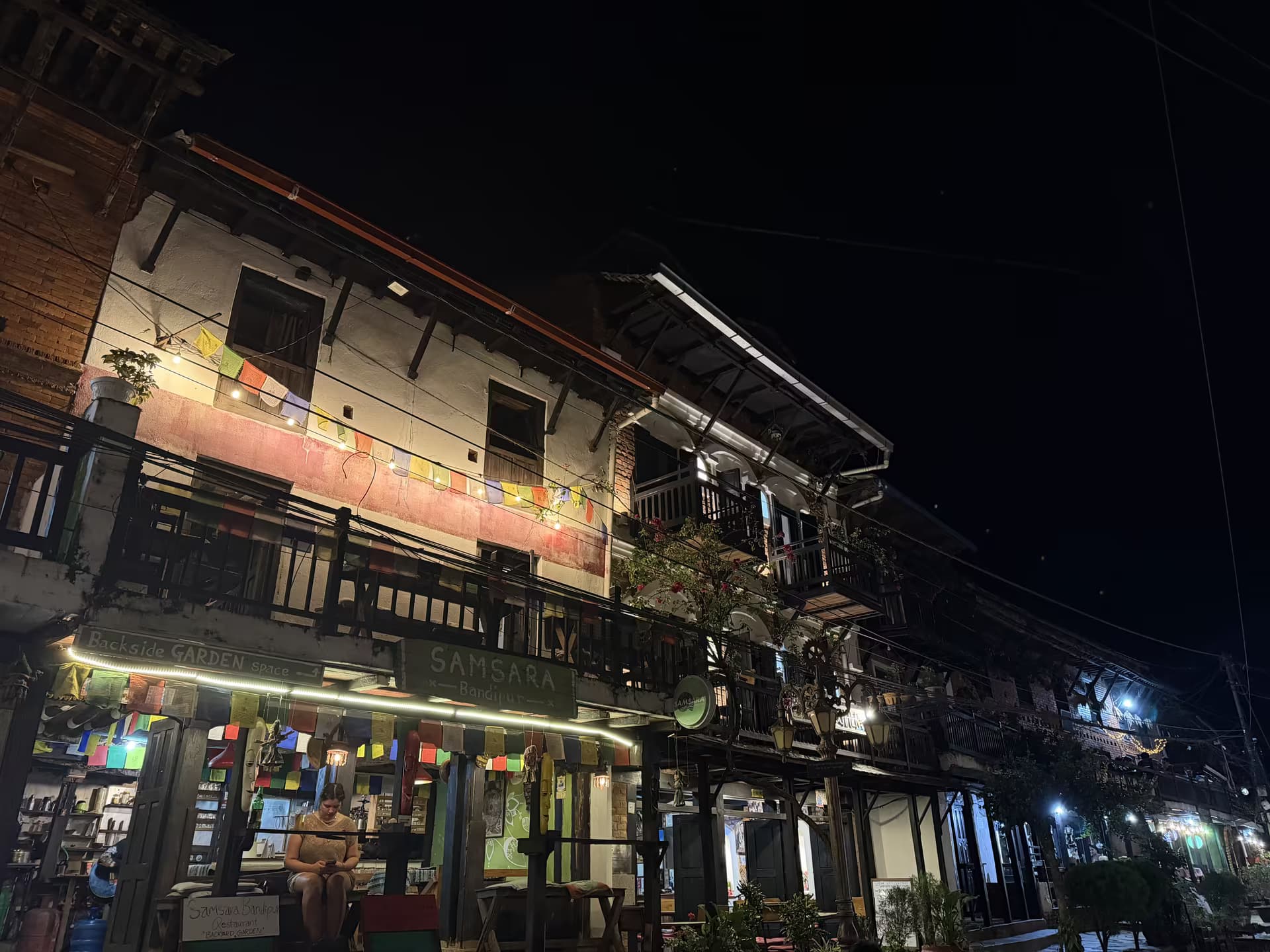 Bandipur heritage buildings with prayer flags and shopfronts lit at night