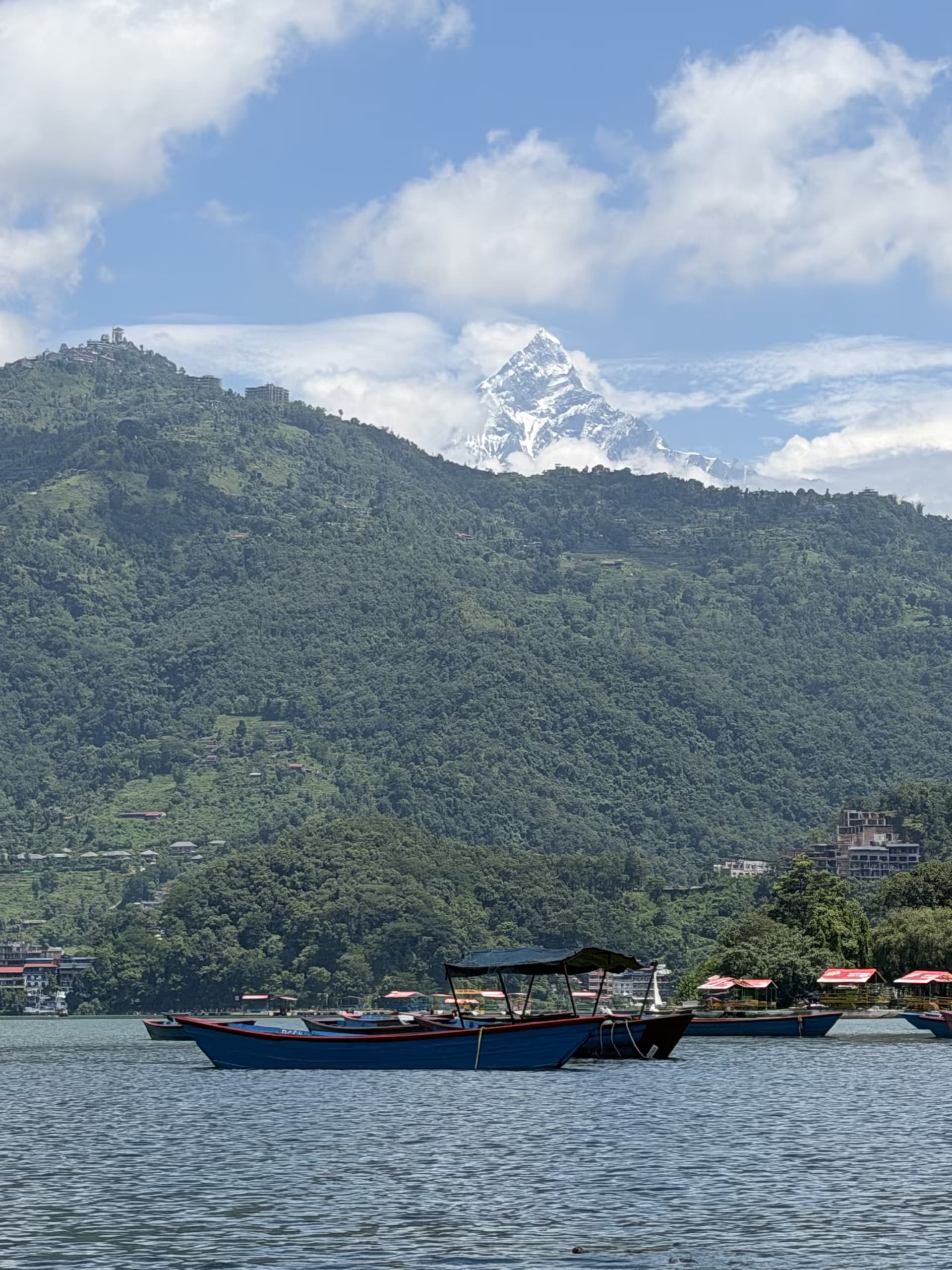 Snow-capped Machhapuchhre rising above Phewa Lake and forested ridges