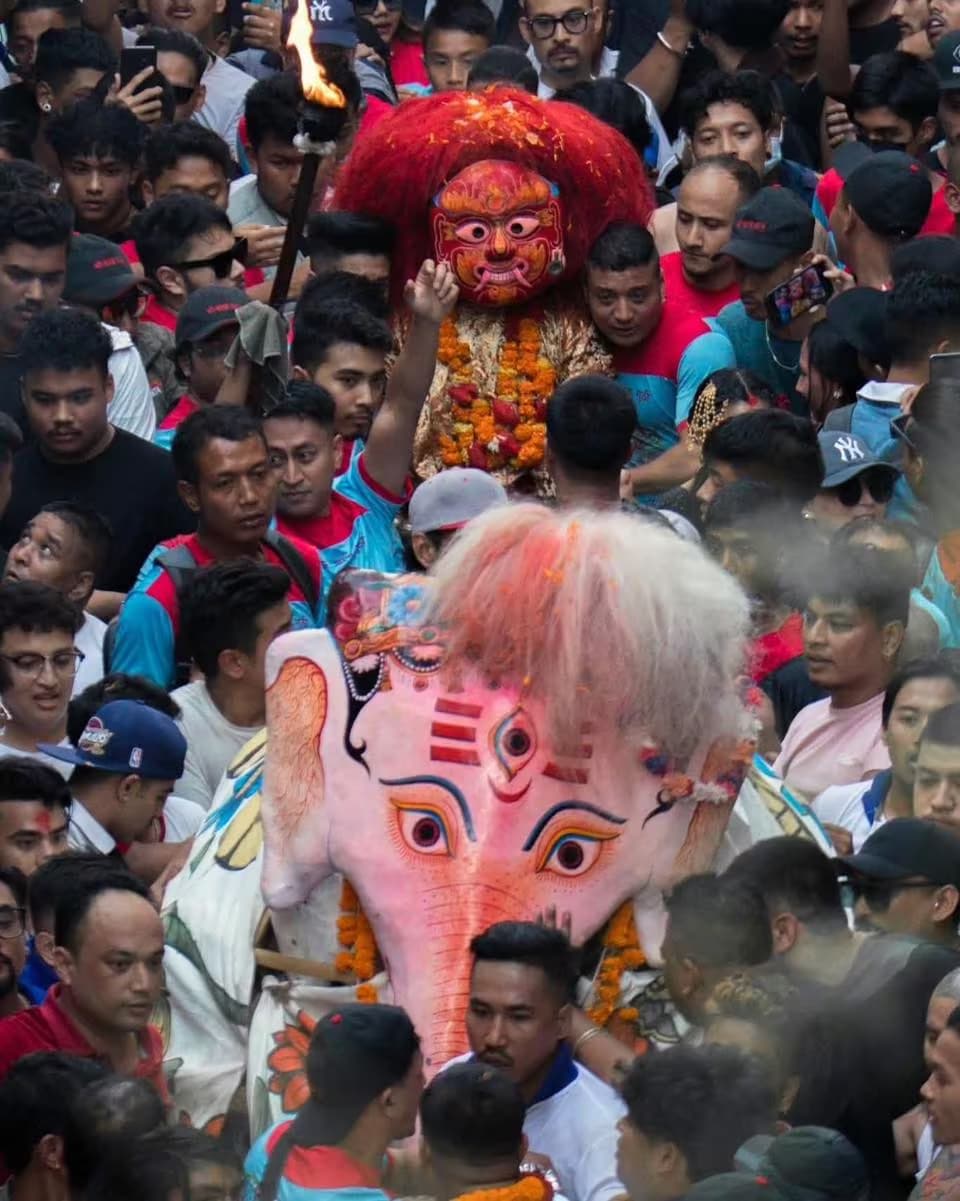 Bhairav's red-haired mask and Pulu Kisi the white elephant carried above a dense crowd