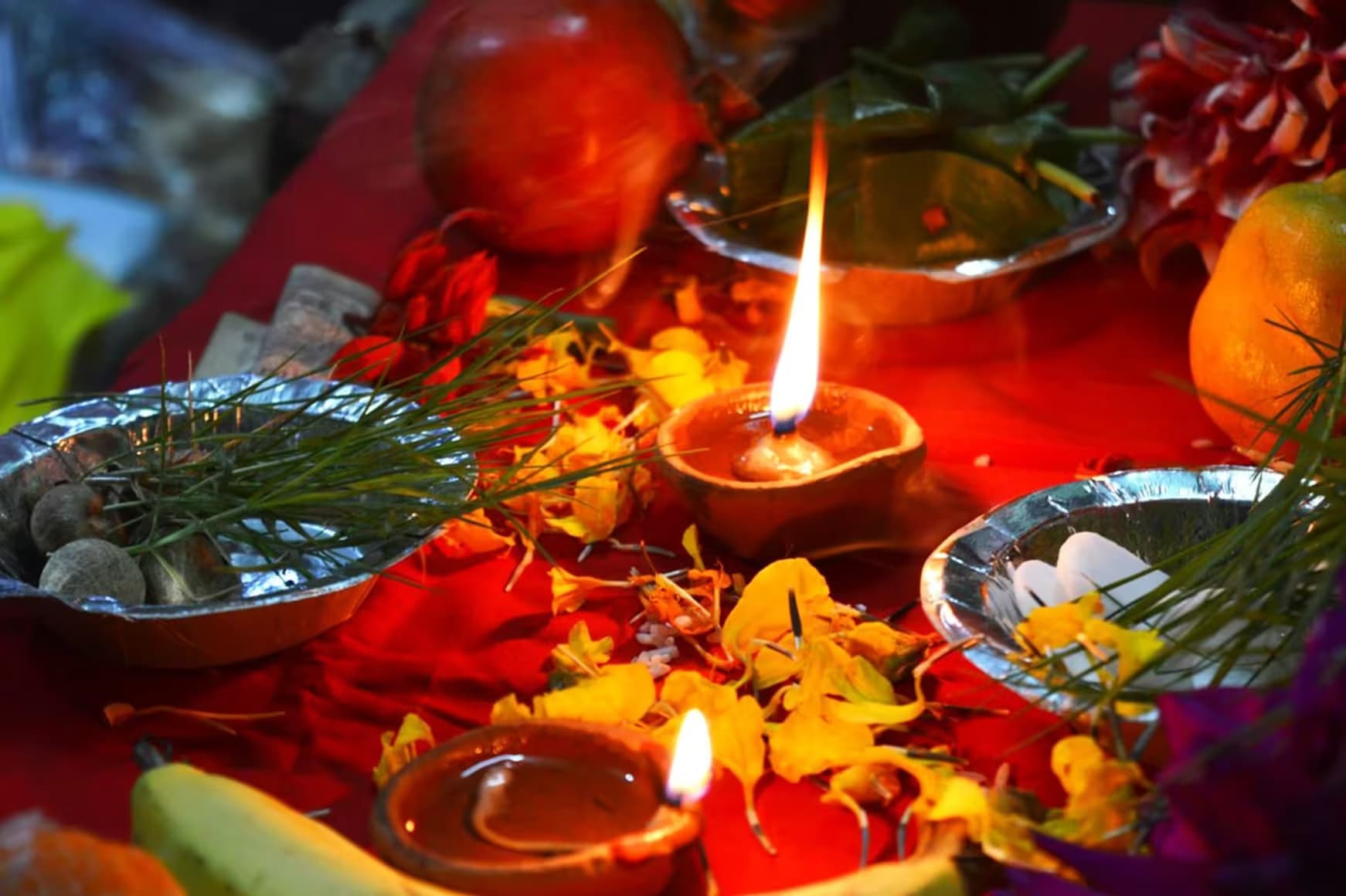 Puja offerings with oil lamp flame and flowers