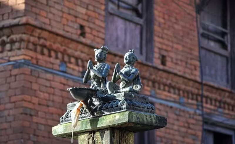 Traditional Newari statues atop a pillar in Bandipur